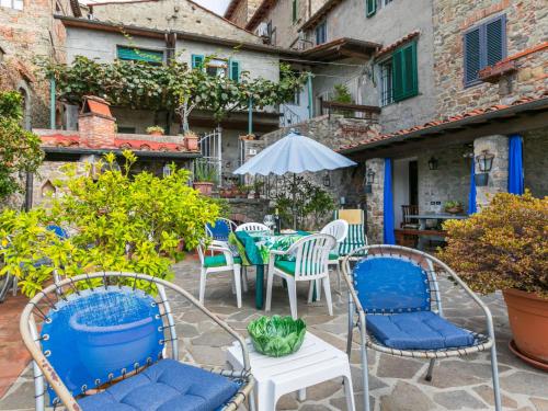 科洛迪Apartment La casa del Fale di Collodi by Interhome的庭院配有桌椅和遮阳伞。