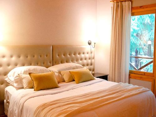 拉安戈斯图拉镇ONA Apart Hotel and Spa的一间卧室配有一张带黄色枕头的大床