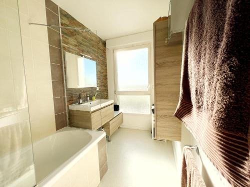 圣埃尔布兰Le panoramique的带浴缸和盥洗盆的浴室