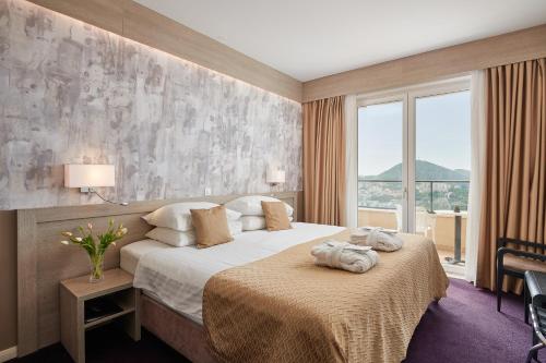 杜布罗夫尼克亚德里亚酒店的酒店客房设有一张床和一个大窗户