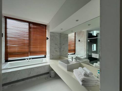 珍南海滩La Mer Luxury Private Pool Villa的带浴缸、水槽和镜子的浴室