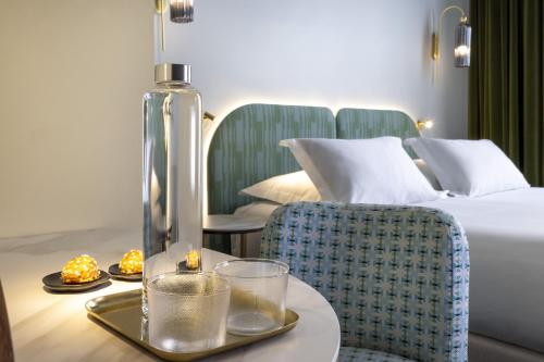 巴黎Hôtel L de Lutèce的配有一张床和一张桌子及托盘的酒店客房