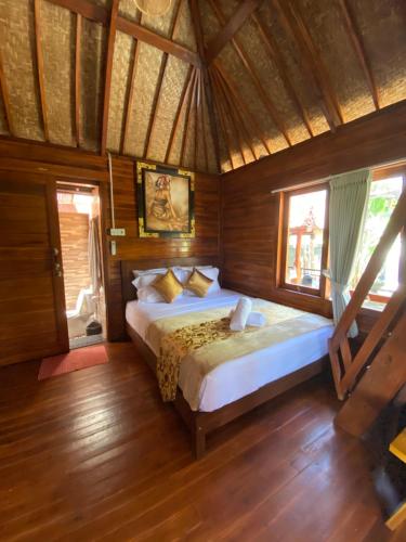 登巴萨Pondok Biu的木制客房内的一间卧室配有一张大床