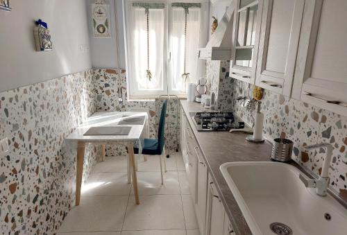 罗马Tra le antiche mura e Garbatella的白色的厨房设有水槽和窗户