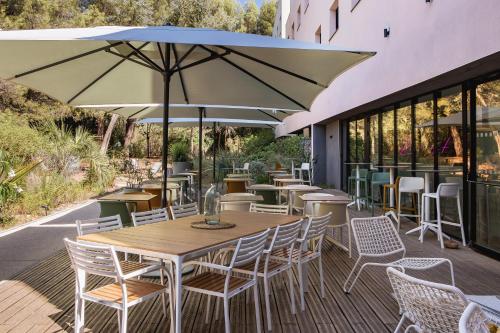 维特罗勒金色郁金香马赛机场酒店的一个带桌椅和遮阳伞的户外庭院