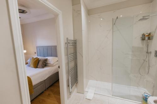 里士满WENSLEYDALE, OLD SCHOOL ROOMS - Ground Floor Luxury Apartment in Richmond, North Yorkshire的带淋浴、床和淋浴的浴室
