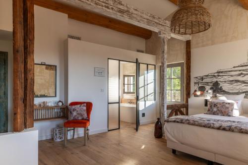 马赛LA BASTIDE DES CULS-ROUSSET的一间卧室配有一张床和一把椅子