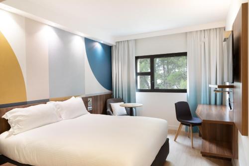 维特罗勒金色郁金香马赛机场酒店的一间酒店客房,配有一张白色的床和一张书桌