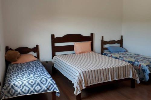 卡舒埃拉坎普Sítio da Serra em Ouro Preto MG的两张睡床彼此相邻,位于一个房间里