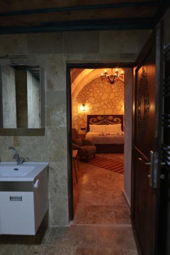 乌奇希萨尔Stone Owl Otel的一间带水槽的浴室和一张位于客房内的床