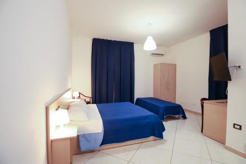 庞特卡格纳诺max hotel e restaurant的一间卧室配有蓝色的床和蓝色窗帘