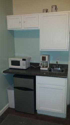 佛罗伦萨Pine Street Studios的厨房配有白色橱柜、水槽和微波炉