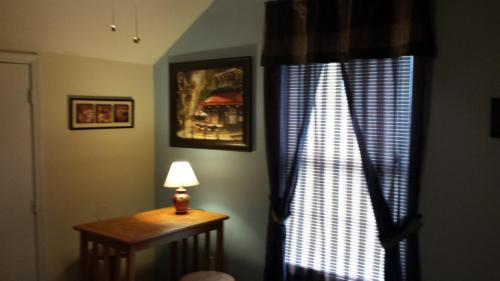 佛罗伦萨Pine Street Studios的客房设有带桌子和灯的窗户。