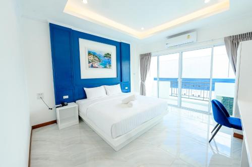 黎府Marble Arch De Loei Hotel的一间卧室设有一张大床和蓝色的墙壁