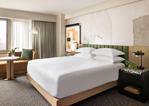 纽约Kimpton Hotel Theta, an IHG Hotel的卧室配有一张白色的大床和一张沙发。