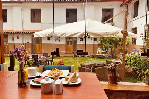 库斯科圣佩德罗修道院酒店的餐桌,带食物盘和雨伞