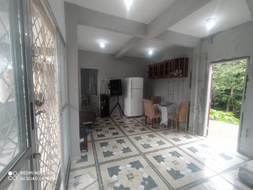 贝伦Casa Ariramba Mosqueiro的一间铺有瓷砖地板的客厅和一间厨房