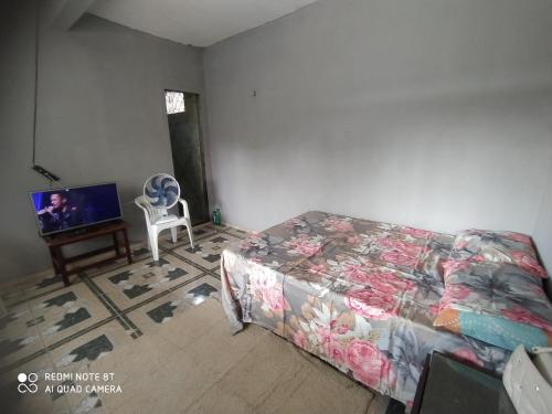 贝伦Casa Ariramba Mosqueiro的一间带床和电视的客厅