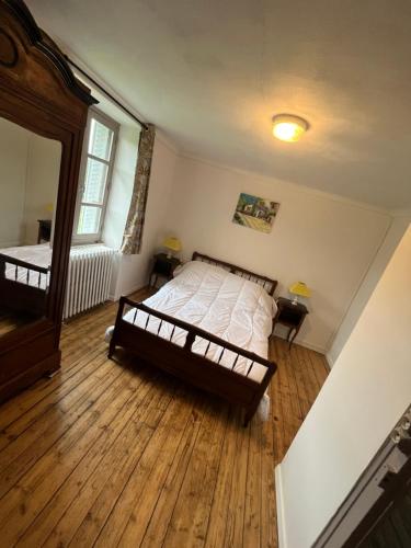 Saint-Martin-Châteaumaison de campagne的一间卧室配有一张床,铺有木地板