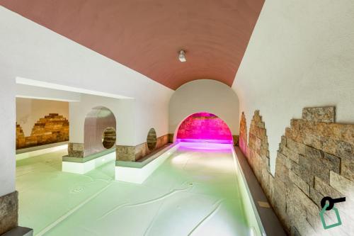 利沃诺HOTIDAY Hotel Livorno的一座室内泳池,位于一座粉红色的建筑中