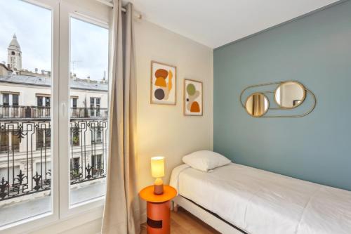 巴黎Hôtel Juliette的一间卧室设有一张床和一个大窗户