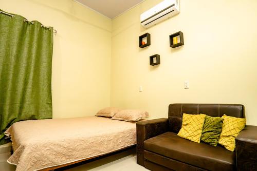 奎波斯城Apartamento Aliga 1的一间卧室配有一张床、一张沙发和一个窗口
