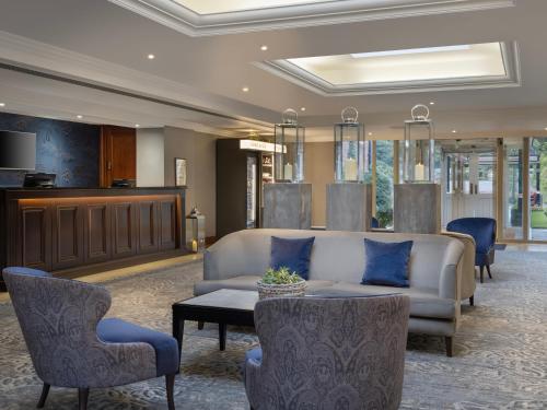 沃尔斯雷Delta Hotels by Marriott Worsley Park Country Club的大堂配有沙发、椅子和桌子