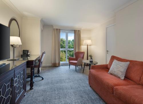 沃尔斯雷Delta Hotels by Marriott Worsley Park Country Club的客厅配有沙发和书桌。