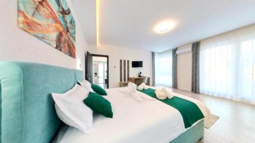 索瓦塔Vila Diamond Lux&Spa的一间卧室配有一张带绿色和白色枕头的大床