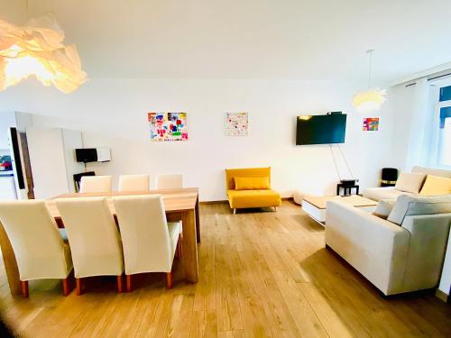 沙勒罗瓦Résidence Deluxe的客厅配有桌椅和电视。