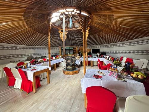 DzuunmodSara's Camp的大型用餐室配有桌子和红色椅子