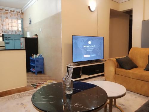 MeruCeeJ'S Airbnb的一间带电视和桌子的客厅