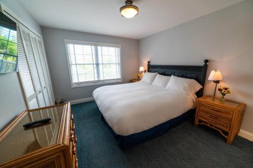 五月岬郡矶鹞海滩俱乐部酒店的卧室设有一张白色大床和两个窗户。