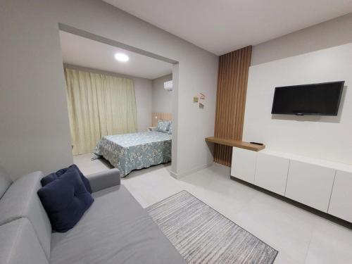 波苏斯-迪卡尔达斯Apartamentos modernos e aconchegantes no centro.的客厅配有沙发和1张床