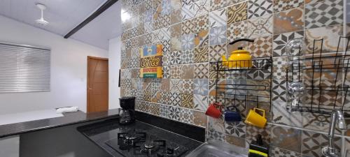 阿布拉奥KITNET vila do Abraão的一间带水槽和瓷砖墙的厨房