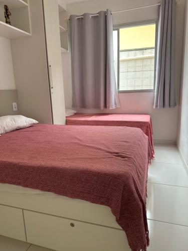瓜拉派瑞Apto 2 Quartos Perfeito的一间卧室设有两张床和窗户。