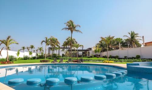 阿卡普尔科Acapulco diamante, club de playa privado, canchas pádel para 8 huéspedes的棕榈树度假村的游泳池