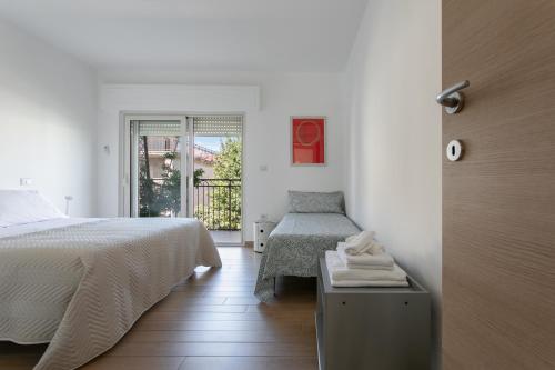 阿布鲁齐的罗塞托Grazioso appartamento seconda fila sul mare - wifi的白色的卧室设有床和窗户