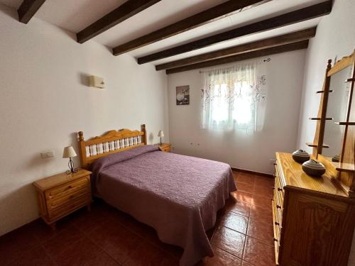 大加那利岛拉斯帕尔马斯Casa Fagajesto的一间卧室配有一张床、一个梳妆台和一扇窗户。