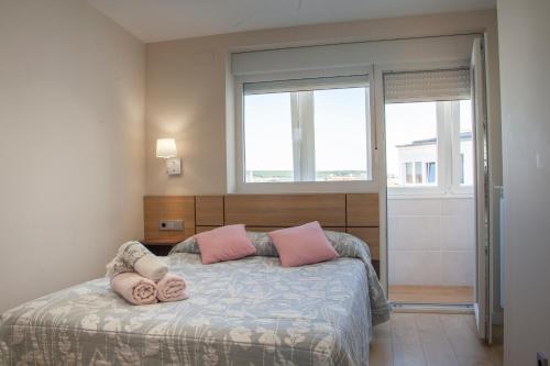 莱昂The View - Apartamento reformado con vistas a la Catedral - leonapartamentos的一间卧室配有带粉红色枕头的床。