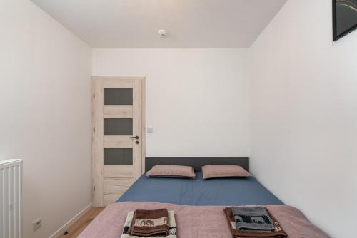弗罗茨瓦夫ApartWro 3th - apartament przy dworcu głównym PKP, balkon, garaż, rowery的一间卧室设有蓝色的床和白色的墙壁