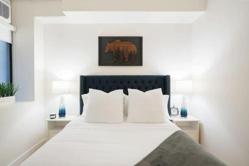 纽约Luxury 2BR Duplex 5min to Central Park的一间卧室配有带白色床单和枕头的床。
