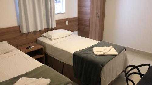 瓦拉达里斯州长市奥缇斯酒店的酒店客房带两张床和一张桌子以及椅子。