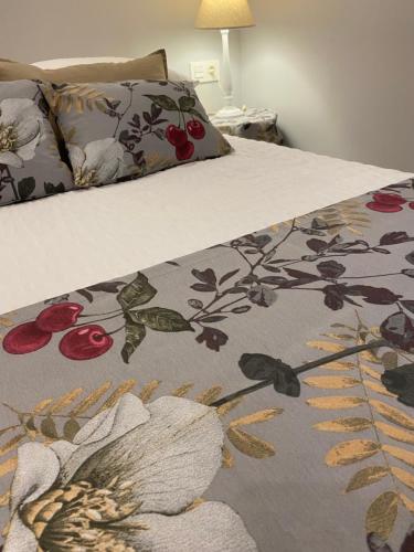 萨拉戈萨Precioso y céntrico apartamento的床上有鲜花的毯子