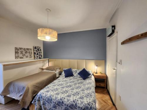 门多萨Casa del Buen Viaje的一间卧室配有一张蓝色墙壁的床