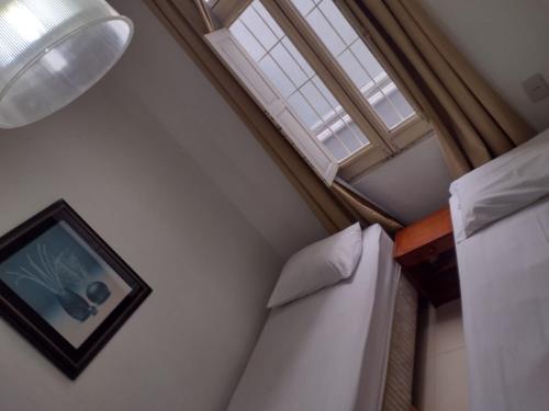 卡鲁阿鲁Pousada Palace Hotel的一间卧室设有两张床和窗户。