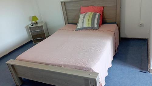 萨莱比梅Maison du soleil的一间小卧室,配有一张带粉色床单的床和一个床头柜