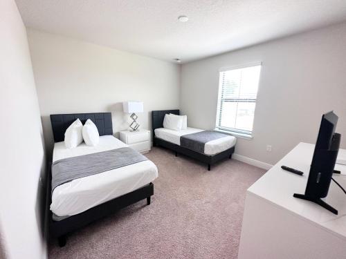 海恩斯城Balmoral Resort-211MCV的一间卧室配有一张床和一张书桌及电视