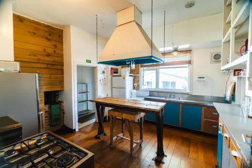 梅斯文派恩代尔旅馆及公寓度假屋的厨房配有木桌和蓝色岛屿