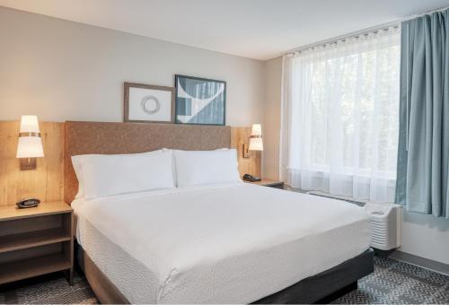 费德勒尔韦Staybridge Suites Federal Way - Seattle South , an IHG Hotel的卧室配有白色的床和窗户。